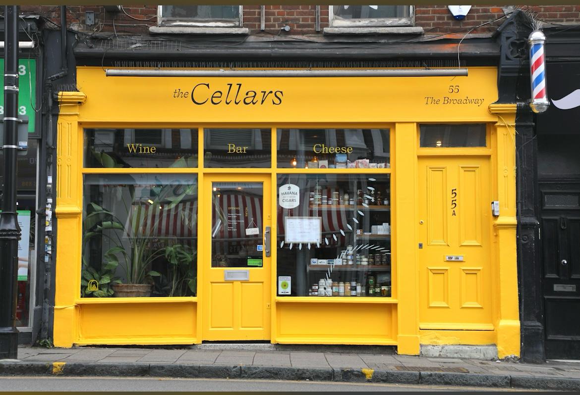 The yellow traditional shop front of The Cellars in Crouch End, North London.